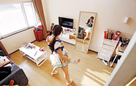 一名爱好Cosplay的房客在魔方公寓房间里练习舞蹈动作。图/新华